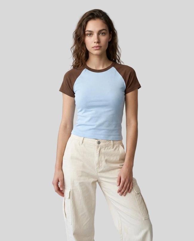 Woman wearing the TrackLine Raglan Baby Tee in Sky Blue and Coffee from the front showing its fitted cropped silhouette
