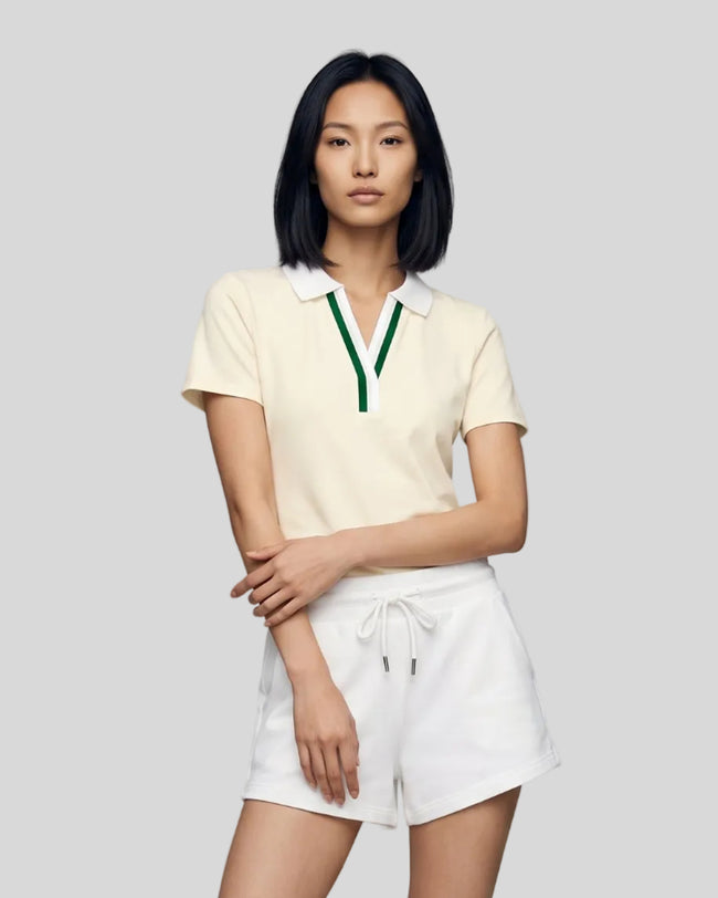 Model wearing the beige Athlesi TrackLine Rally Polo Shirt with white and green contrast neckline, front view