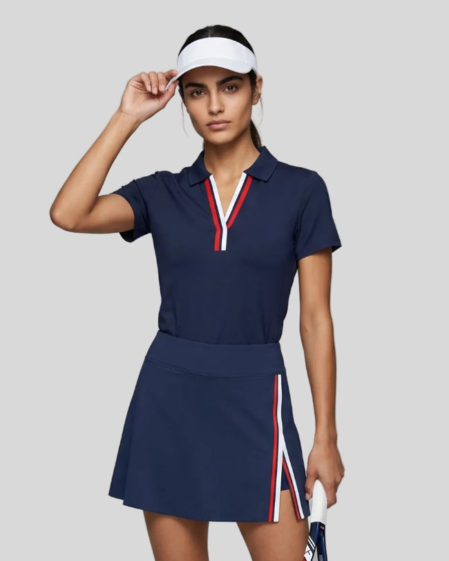 Model wearing the navy blue Athlesi TrackLine Rally Polo Shirt with red and white contrast neckline, front view