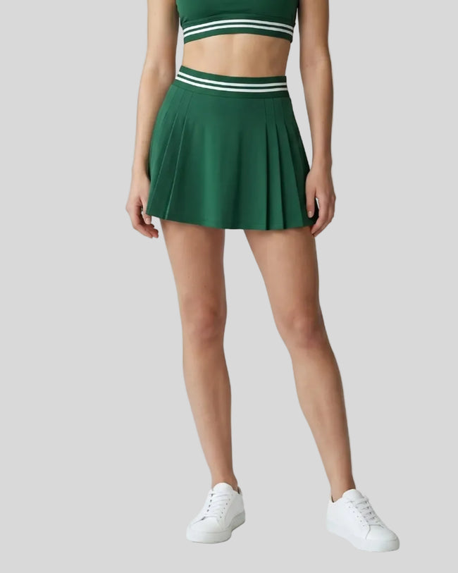 Woman wearing TrackLine Rally Skirt in blackish green front view with retro court-inspired styling