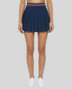 Woman wearing TrackLine Rally Skirt in navy blue front view with retro court-inspired styling
