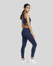 Full body angled back view of TrackLine Rally Sports Bra in navy blue with criss-cross athletic styling