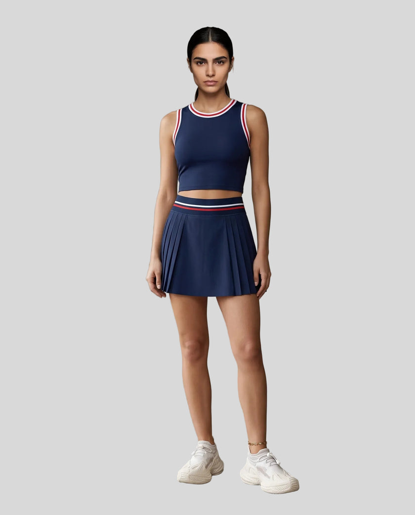 Front view of Model wearing the TrackLine Rally Tank in Navy Blue with Red, paired with Trackline Rally Skirt in Navy Blue.