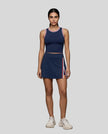 Front view of Model wearing the TrackLine Rally Tank in Navy Blue with Red, paired with Trackline Rally Slit Skirt in Navy Blue.