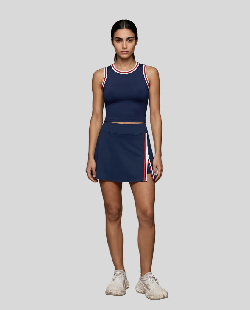 Front view of Model wearing the TrackLine Rally Tank in Navy Blue with Red, paired with Trackline Rally Slit Skirt in Navy Blue.