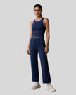 Front view of Model wearing the TrackLine Rally Tank in Navy Blue with Red, paired with CoreLine Yoga Pants in Navy Blue.