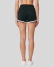 Back view of TrackLine Retro Shorts in Black with White contrast binding on model