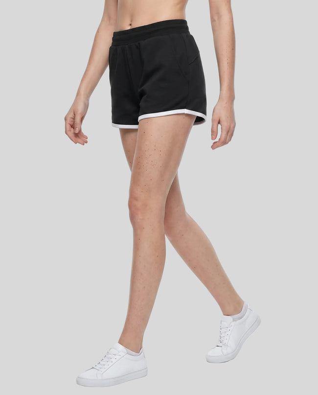 Side angled front view of model wearing the Athlesi TrackLine Retro Shorts in black and white