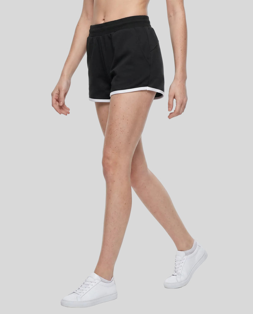 Side angled front view of model wearing the Athlesi TrackLine Retro Shorts in black and white