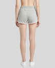Back view of TrackLine Retro Shorts in Flower Gray with White contrast binding on model