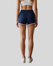 Back view of TrackLine Retro Shorts in Navy Blue with White contrast binding on model