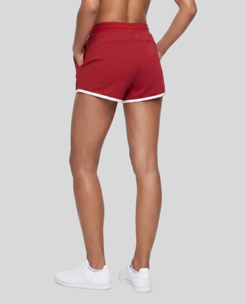 Back angle view of TrackLine Retro Shorts in Red with White contrast binding on model
