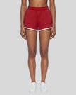 Model wearing TrackLine Retro Shorts in Red with White contrast binding front view