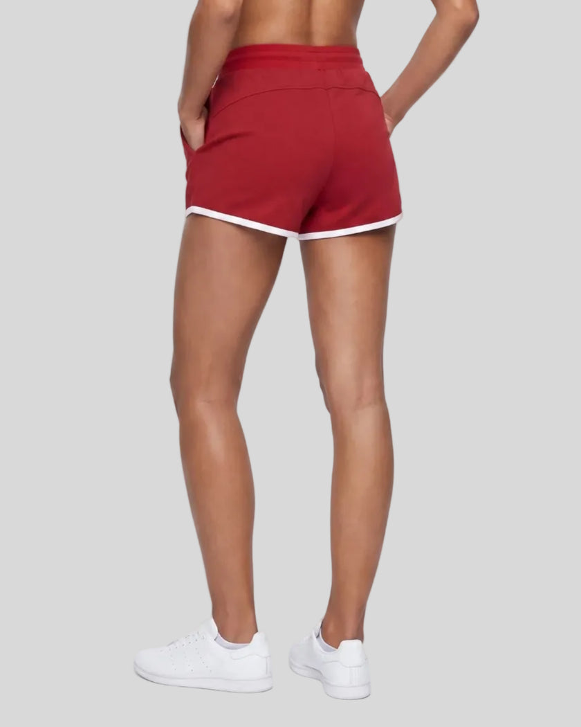 Angled back view of model wearing the Athlesi TrackLine Retro Shorts in red and white
