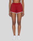 Model wearing the Athlesi TrackLine Retro Shorts in red and white front view