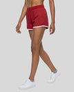 Side angled front view of model wearing the Athlesi TrackLine Retro Shorts in red and white