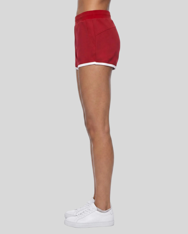 Side profile of model wearing the Athlesi TrackLine Retro Shorts in red and white