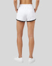 Back view of model wearing the Athlesi TrackLine Retro Shorts in white and black