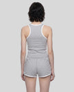 Back view of model wearing the Athlesi TrackLine Retro Tank in flower gray and white with matching retro shorts