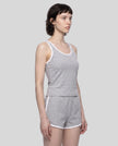Angled front view of model wearing the Athlesi TrackLine Retro Tank in flower gray and white