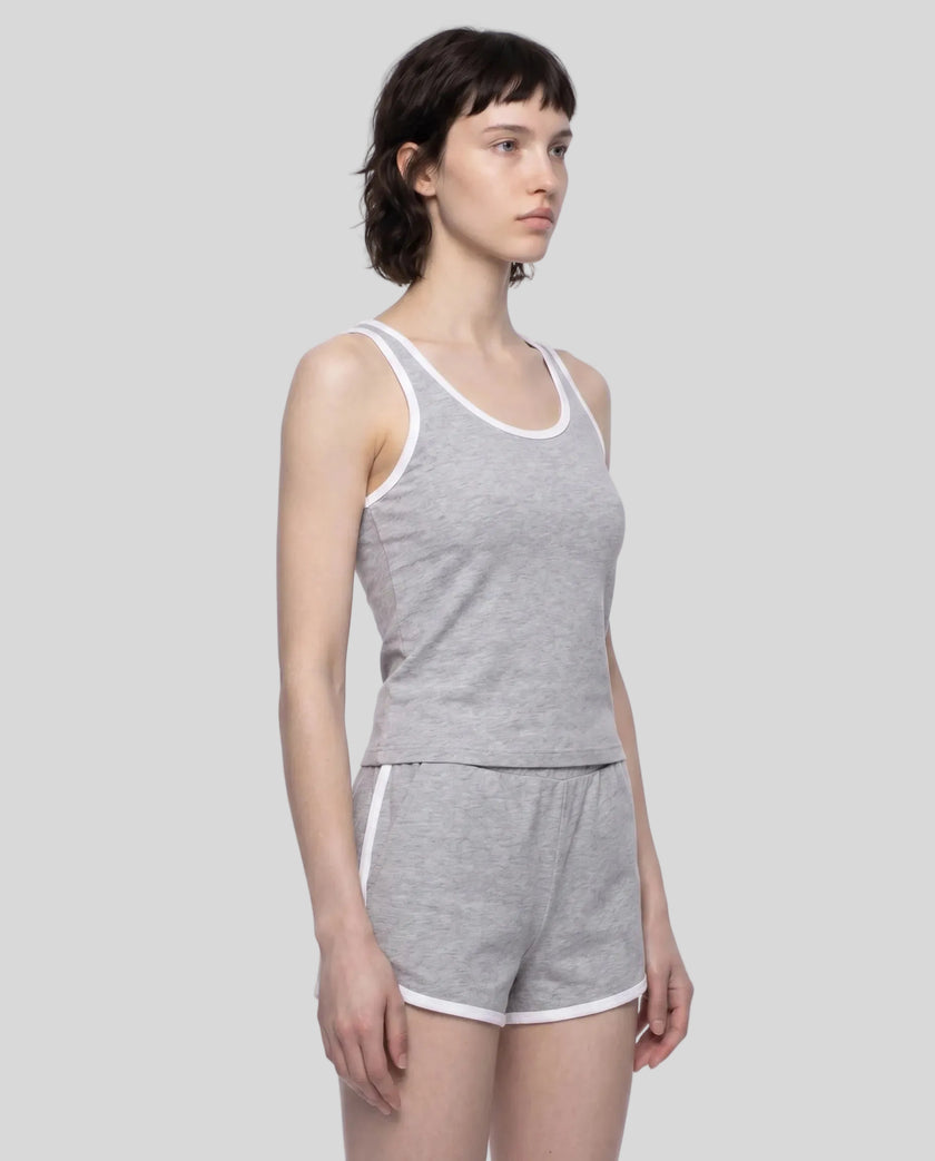 Angled front view of model wearing the Athlesi TrackLine Retro Tank in flower gray and white