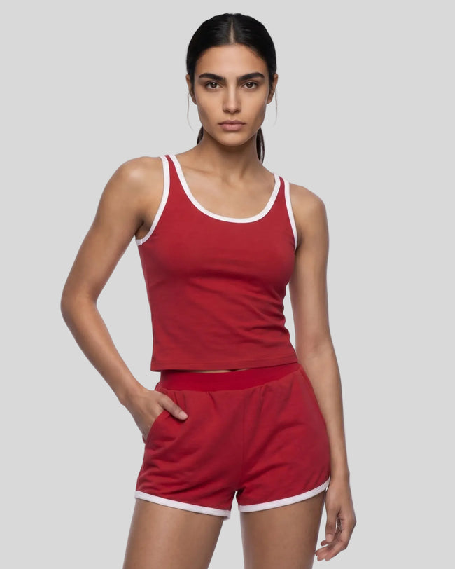 Angled front view of model wearing the Athlesi TrackLine Retro Tank in red and white