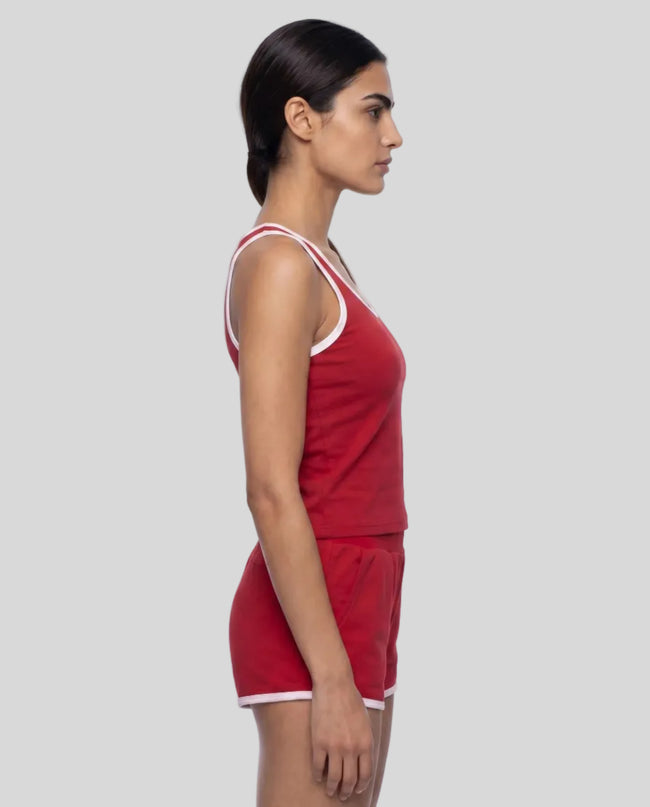 Side profile of model wearing the Athlesi TrackLine Retro Tank in red and white