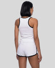 Back view of model wearing the Athlesi TrackLine Retro Tank in white and black with matching retro shorts