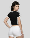 Back view of a woman wearing the Athlesi TrackLine Retro V-Neck Tee in black