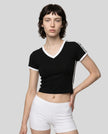 Mid body front view of a woman wearing the Athlesi TrackLine Retro V-Neck Tee in black