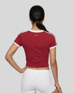 Back view of a woman wearing the Athlesi TrackLine Retro V-Neck Tee in red