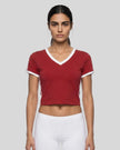 Mid body front view of a woman wearing the Athlesi TrackLine Retro V-Neck Tee in red