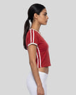 Side view of a woman wearing the Athlesi TrackLine Retro V-Neck Tee in red