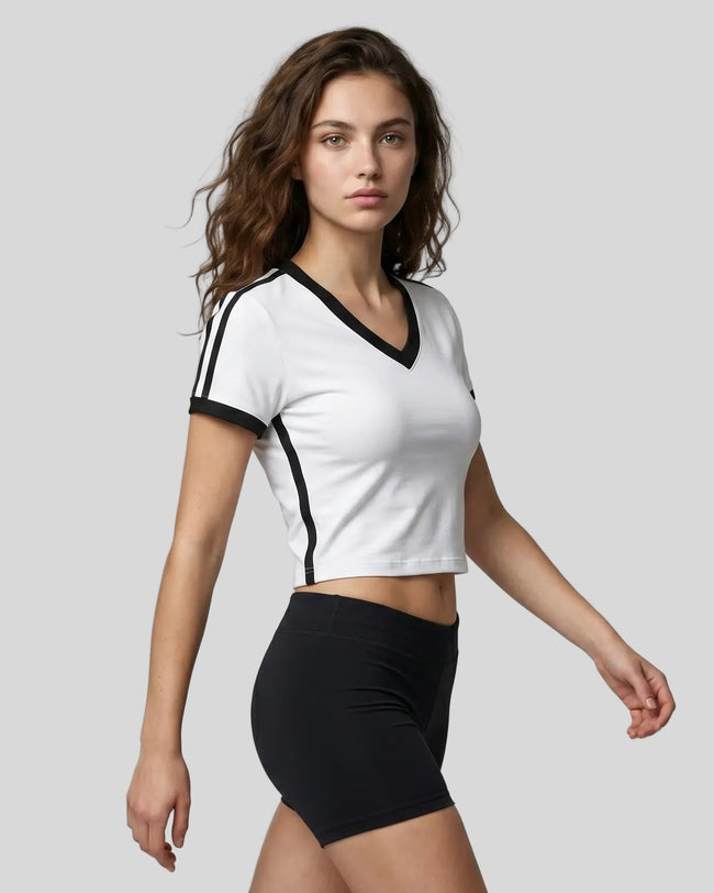 Right angle view of a woman wearing the Athlesi TrackLine Retro V-Neck Tee in white