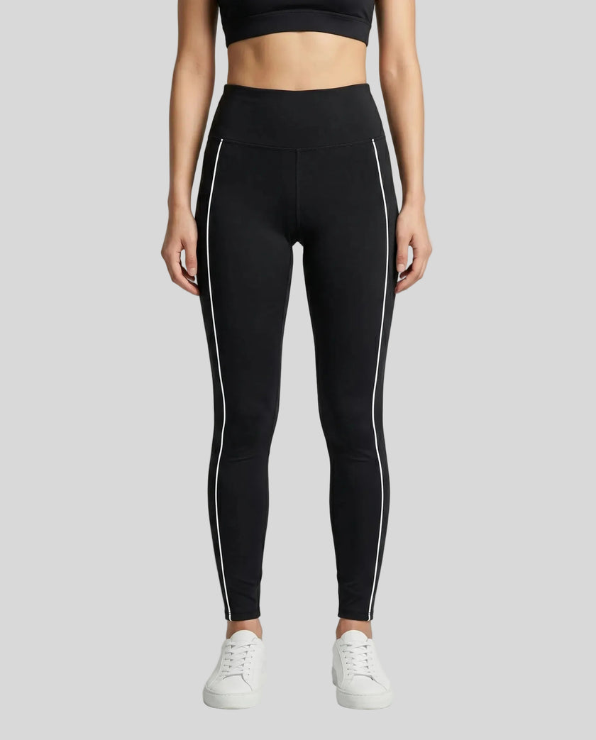 Front view of a model wearing Trackline Riviera Leggings leg hem closeup in Black