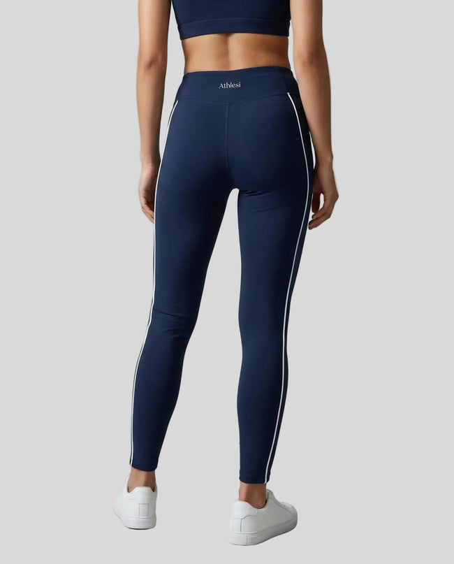 Rear view of a model wearing Trackline Riviera Leggings leg hem closeup in Navy Blue