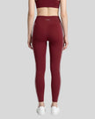 Rear view of a model wearing Trackline Riviera Leggings leg hem closeup in Wine Red