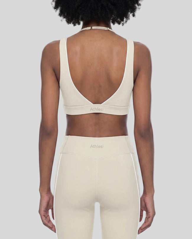 Rear view of a woman modeling the Trackline Riviera Sports Bra in Light Apricot