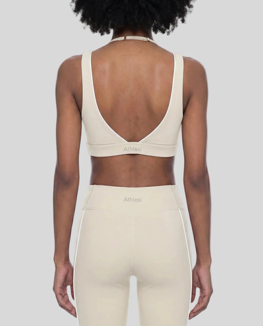 Rear view of a woman modeling the Trackline Riviera Sports Bra in Light Apricot