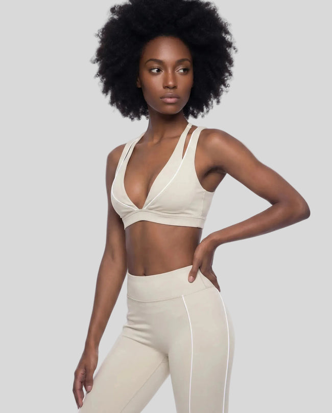 Front angle view of a woman modeling the Trackline Riviera Sports Bra in Light Apricot