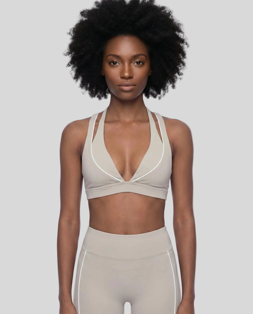 Front view of a woman modeling the Trackline Riviera Sports Bra in Light Apricot