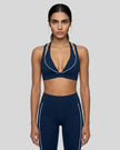 Front view of a woman modeling the Trackline Riviera Sports Bra in Navy Blue