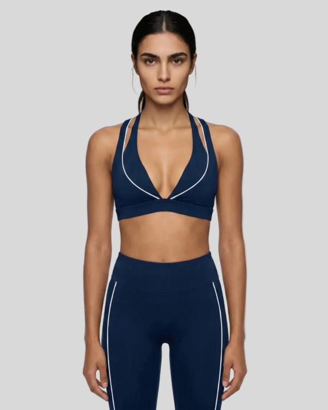 Front view of a woman modeling the Trackline Riviera Sports Bra in Navy Blue