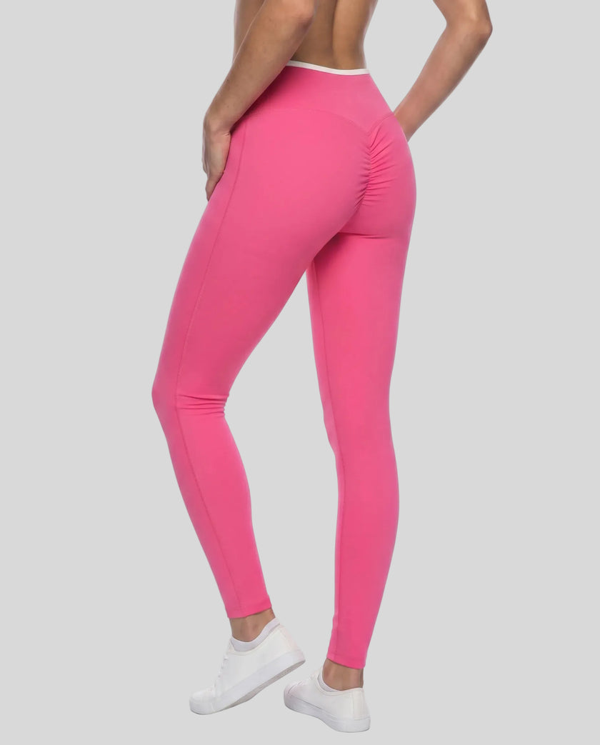 Back angled view of TrackLine Sculpt Leggings in rose pink and white on model