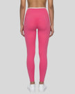 Back view of model wearing pink TrackLine Sculpt Leggings featuring contour shaping detail