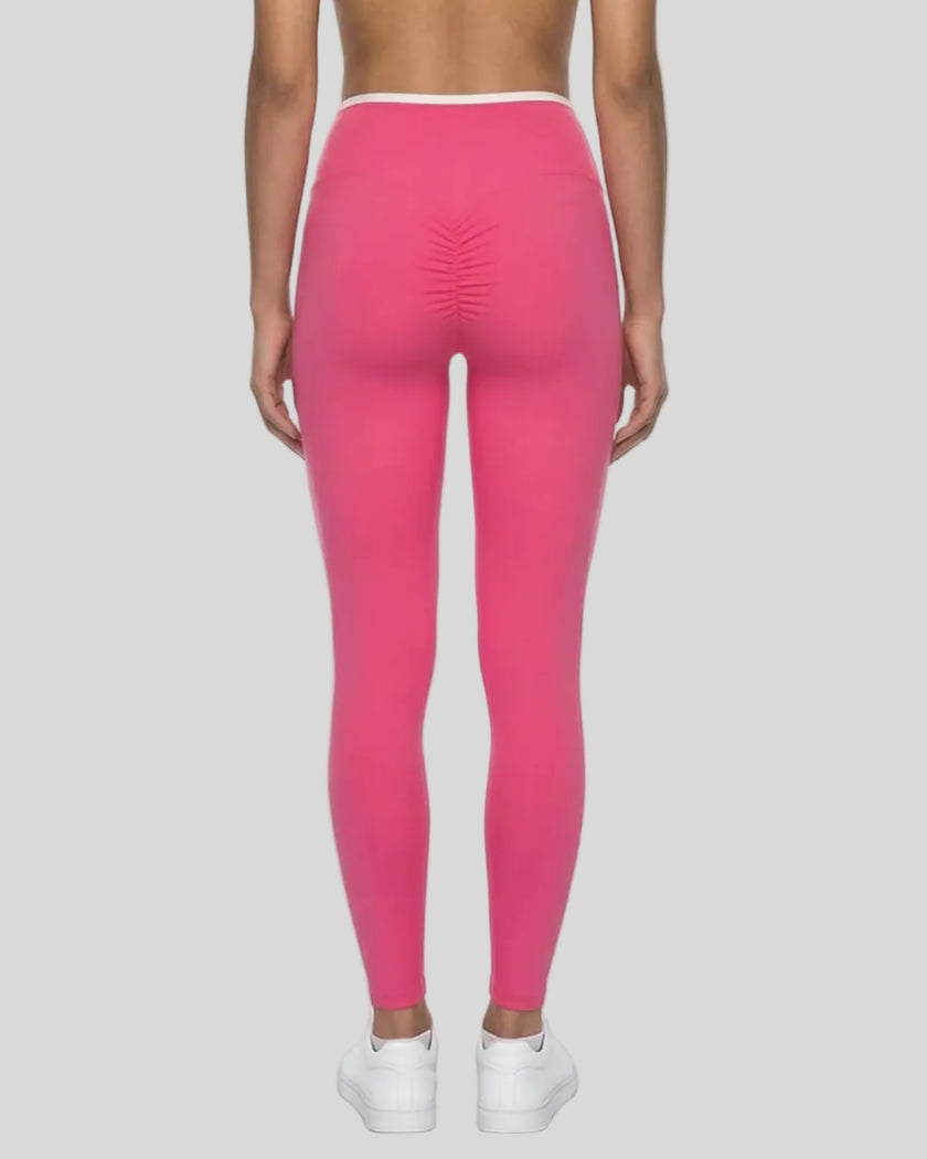 Back view of model wearing pink TrackLine Sculpt Leggings featuring contour shaping detail