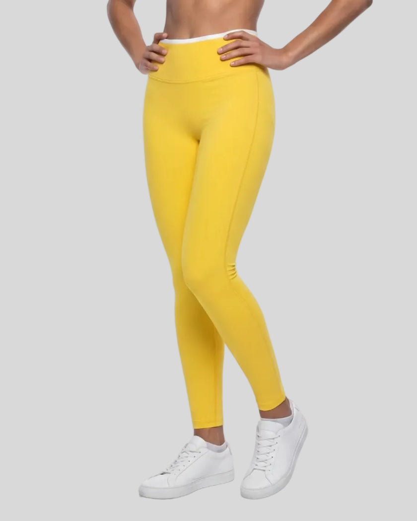 Angled front view of model wearing TrackLine Sculpt Leggings in yellow and white
