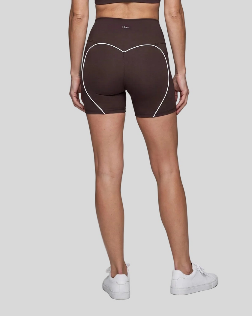 Lower body back view of woman wearing brown TrackLine Sculpt Shorts with curved contrast piping