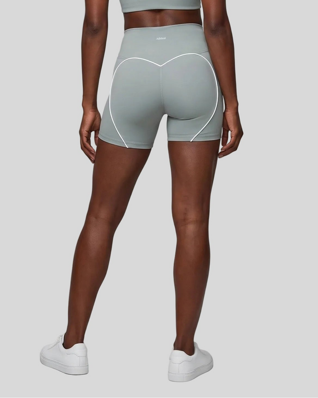 Lower body back view of woman wearing haze blue TrackLine Sculpt Shorts with curved contrast piping