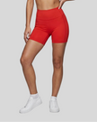 Lower body front view of woman wearing red TrackLine Sculpt Shorts with high-rise waistband